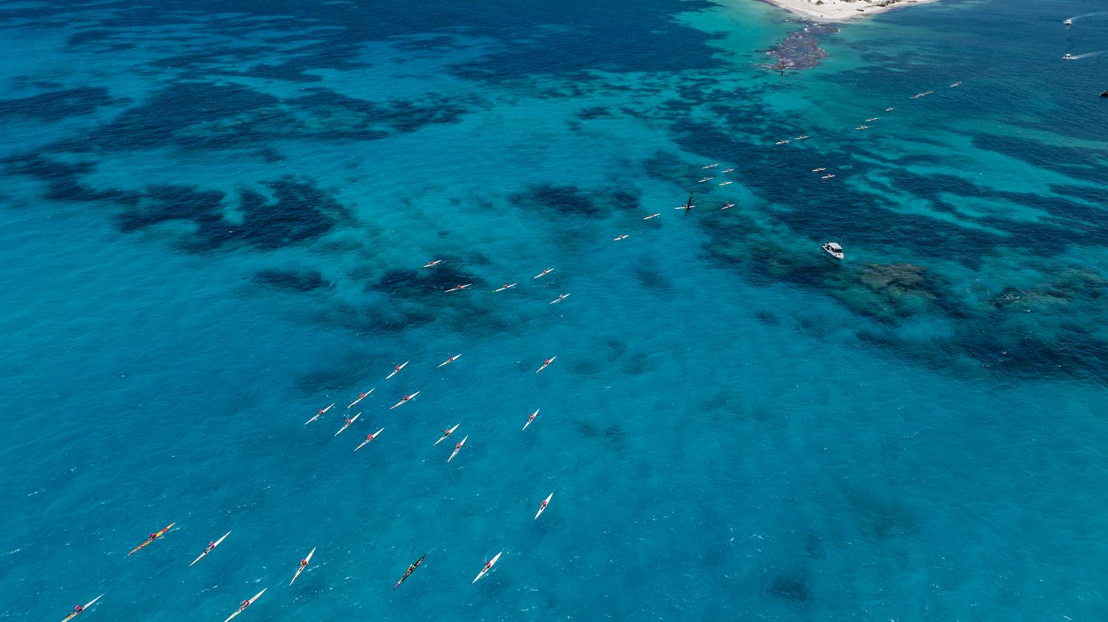 Paddlers on surf skis in clear ocean water